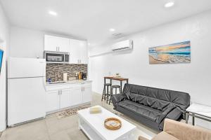 Una sala de estar con un sofá y una cocina. en Boutique One Bdrm Close To Aventura Mall & Beach, en Hallandale Beach