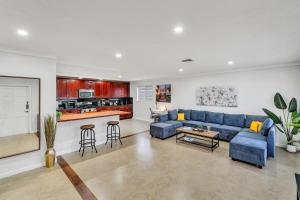 a living room with a blue couch and a kitchen at Vacation Villa W Heated Pool Beach & Casino in Hollywood