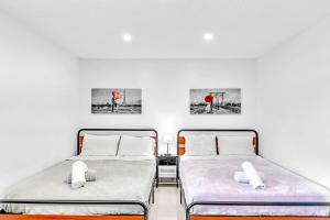 two beds in a room with white walls at New 2 Bed Studio Close To Beach & Casino Ha04 in Hollywood +37 photos