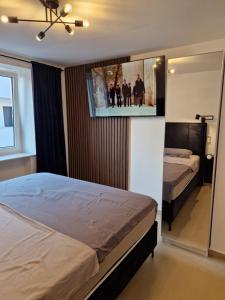 a bedroom with two beds and a flat screen tv at Maris i Maksim in Tribunj