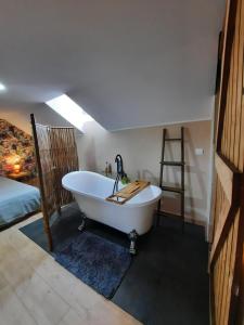 a bath tub in a room with a bed at Chambre Cosy indépendante sans cuisine in Mont-Louis