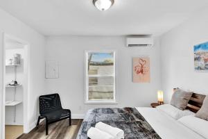 a white bedroom with a bed and a chair at Hallandale Mins From Beach & Aventura Mall Hn01 in Hallandale Beach +32 photos