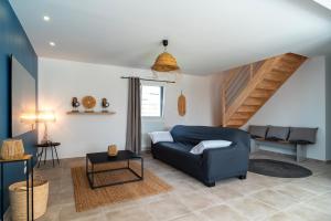 a living room with a blue couch and a table at La Villa Bianca - A 10 min à pied de la plage in Bénodet