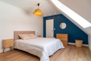 a bedroom with a bed and a blue wall at La Villa Bianca - A 10 min à pied de la plage in Bénodet