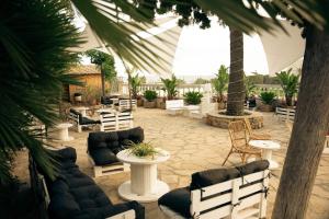 an outdoor patio with chairs and tables and trees at Hotel San Martin in Altafulla