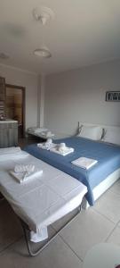 a bedroom with two beds with blue and white sheets at Varkaris Room 1 in Katarráktis