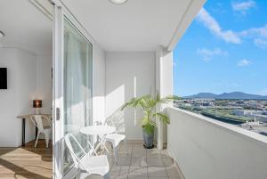 ein Balkon mit Tisch und Stühlen und Aussicht in der Unterkunft 'McLeod Corner' Resort-style Adjacent Apartments in Cairns