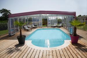 a swimming pool on a wooden deck with two palm trees at Meschers in Saint-Simon-de-Bordes +12 photos