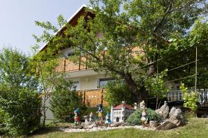 a house with a group of figurines in front of a tree at Gosti&scaron;če Pri Dveh Petelinih in Bled