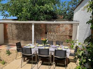 a table and chairs in a garden with a table and chairsktop at Beresford House in Wells next the Sea