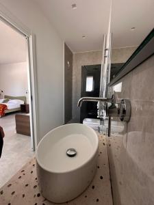 a bathroom with a white sink and a bedroom at B&B Casa Giulivo 1 Pantanagianni in Torre Santa Sabina +12 photos