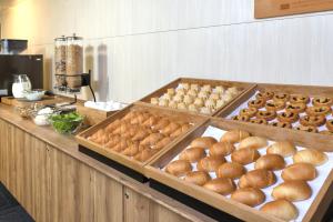 a buffet line with buns and other food on display at Washington R&B Hotel Shin Yokohama Ekimae in Yokohama