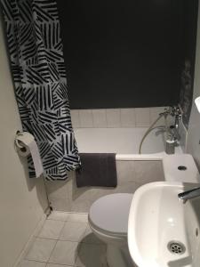 Un baño con lavabo, inodoro y cortina de ducha. en Sady Żoliborskie, en Varsovia 13 fotos más