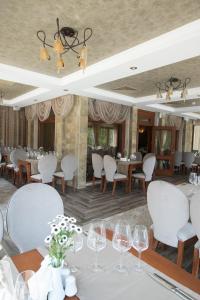 a dining room with white tables and chairs and windows at Marina Residence Boutique Hotel in Varna City