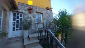 a house with stairs and a door and a plant at Casa cheve in Cangas de Morrazo