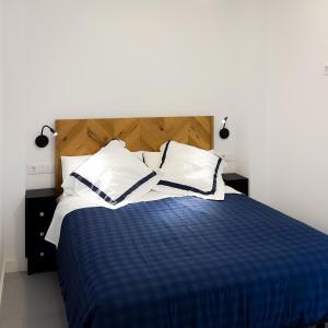 a bedroom with a blue and white bed with white pillows at El Salvador 53 in Las Palmas de Gran Canaria