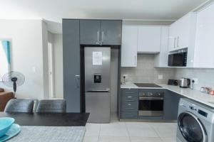 una cucina con frigorifero in acciaio inossidabile di Modern 3 Bedroom Near The Beachfront a Summerstrand Altre 50 foto