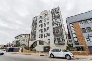 a white car parked in front of a building at Endless Summer Coastal Condo in Summerstrand