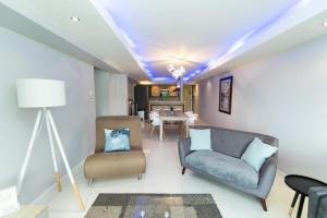 a living room with a couch and chairs and a table at The Pearls 2nd Floor Luxury Apartment in Port Elizabeth