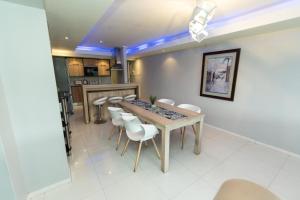 a dining room with a table and white chairs at The Pearls 2nd Floor Luxury Apartment in Port Elizabeth