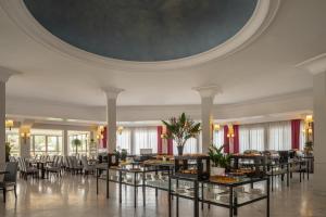 una sala da pranzo con tavoli, sedie e soffitto di Hotel Cristoforo Colombo a Roma