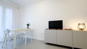 a white dining room with a table and a tv at El Salvador 53 in Las Palmas de Gran Canaria