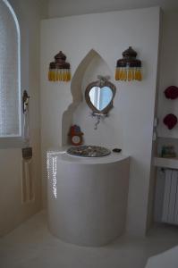 a bathroom with a round tub with a mirror on the wall at Dar Salama in Bizerte