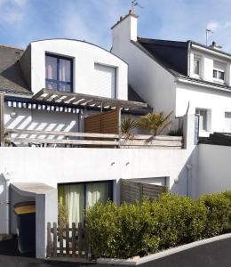 una casa blanca con una valla de madera delante de ella en Duplex 100m de la mer, en Larmor-Plage