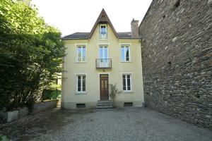a yellow house with a brick wall and a door at Le Clos du Casino in Luchon