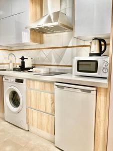 una cucina con forno a microonde e lavatrice di APARTAMENTOS NURIA 19 a Granada Altre 19 foto