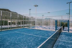 a tennis court with a net on a tennis court at Mangia's Pollina Resort in Cefalù