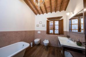 a bathroom with a tub and a sink and a toilet at Villa Delizia - Arceno Rentals Club in San Gusmè +20 photos