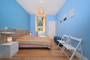 a blue bedroom with a bed and a chair at Le Clos du Casino in Luchon