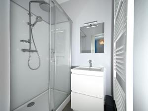 a white bathroom with a sink and a shower at Le Clos du Casino in Luchon +33 photos