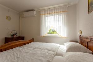 a bedroom with two beds and a window at Gosti&scaron;če Pri Dveh Petelinih in Bled