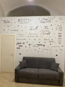 a couch in a room with writing on the wall at La Petite Maison in Naples