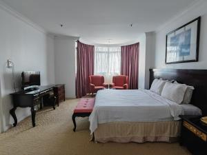 a hotel room with a bed and a desk at The Putra Regency Hotel in Kangar