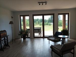 a living room with glass doors and a table and chairs at Sosnówka in Krutyń