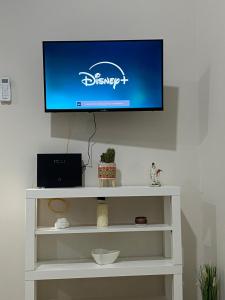 a flat screen tv on top of a white shelf at La Petite Maison in Naples