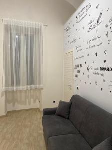 a living room with a couch and writing on the wall at La Petite Maison in Naples