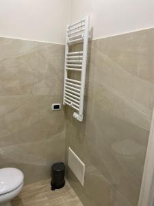 a bathroom with a toilet and a vent on the wall at La Petite Maison in Naples