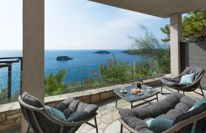 a patio with a view of the ocean at White Orchid Hotel in Sivota