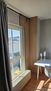 a room with a window and a desk and a table at L19 One Bamberg Hafenareal - 2 SZ, Geräumig, Parkplatz, Autobahnnah - BeMa Apartments in Bamberg