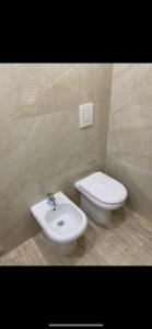 a bathroom with a white toilet and a sink at La Petite Maison in Naples
