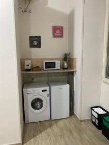 a kitchen with a washing machine and a microwave at La Petite Maison in Naples