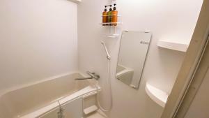 a white bathroom with a shower and a tub at Esperanza 204号室 in Tokyo