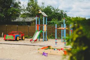 a playground with a slide and play equipment in the sand at Domki MEDYK in Jantar