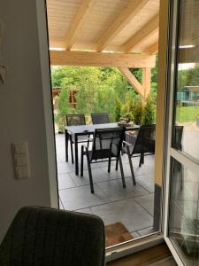 a screened in patio with a table and chairs at Ferienwohnung Rotbuche in Tannenberg