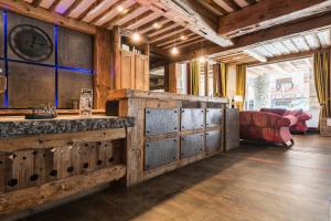 a room with a counter with wooden doors and a clock at CGH Résidence Boutique Le Nevada in Tignes