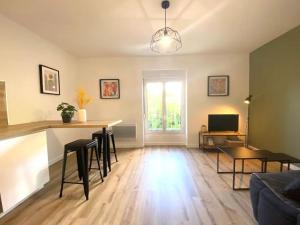 a living room with a table and chairs and a couch at Appartements avenue général Leclerc in Vienne